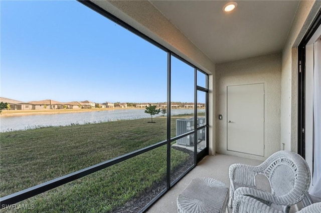 sunroom featuring a water view