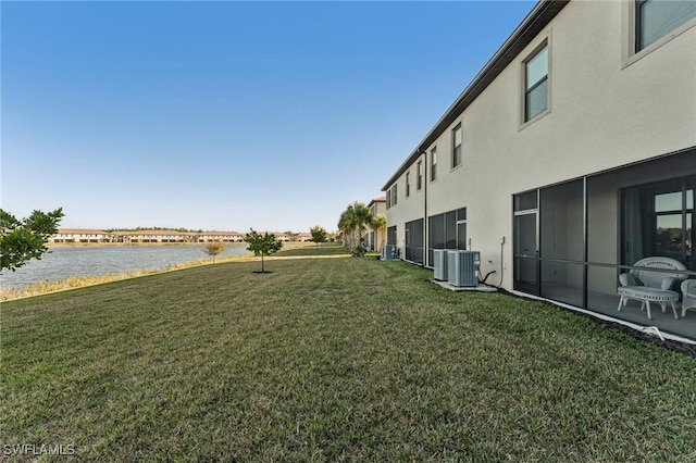 view of yard featuring central air condition unit and a water view