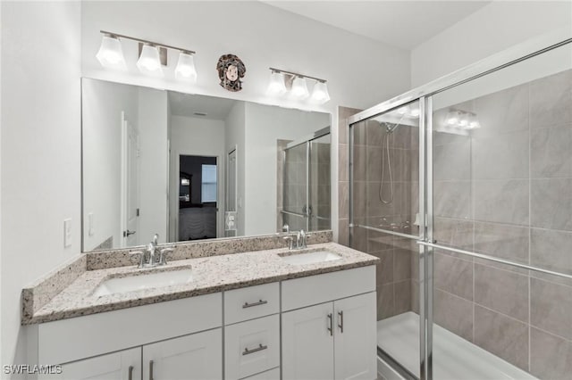 bathroom with vanity and a shower with door