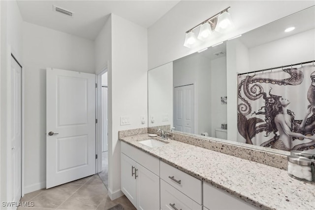 bathroom with toilet, a shower with curtain, vanity, and tile patterned floors