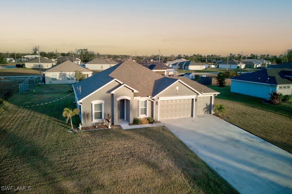 view of front of property featuring a lawn and a garage