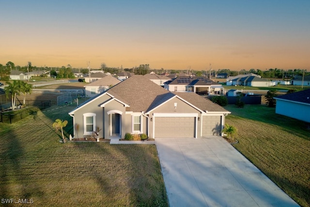 view of front of house featuring a garage and a lawn