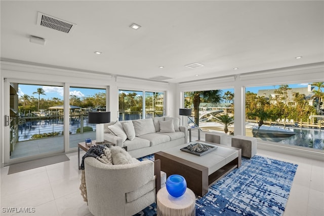 tiled living room with plenty of natural light and a water view