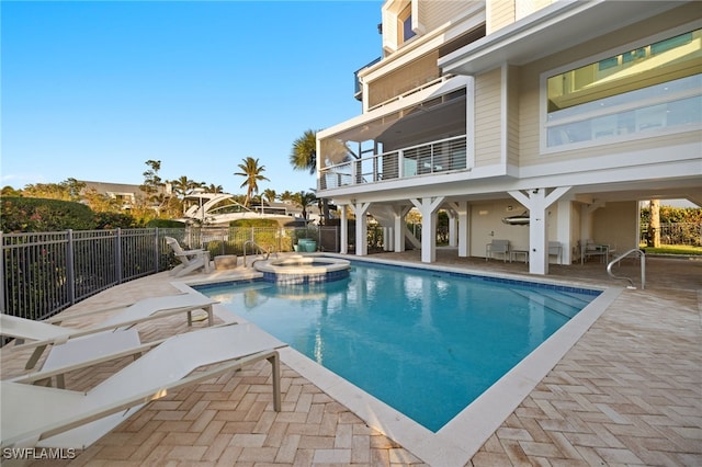 view of swimming pool featuring an in ground hot tub and a patio