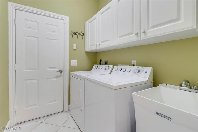 washroom featuring cabinet space, light tile patterned flooring, a sink, and independent washer and dryer