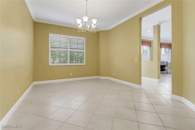 empty room with ornamental molding, baseboards, an inviting chandelier, and light tile patterned floors