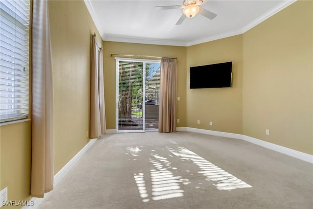 empty room featuring a ceiling fan, crown molding, and baseboards