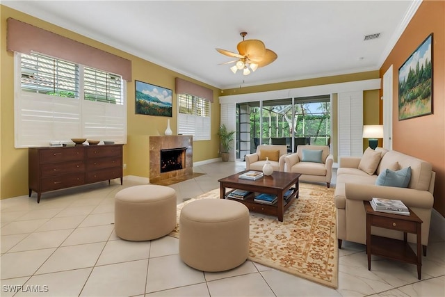 living area featuring a healthy amount of sunlight, visible vents, crown molding, and a high end fireplace