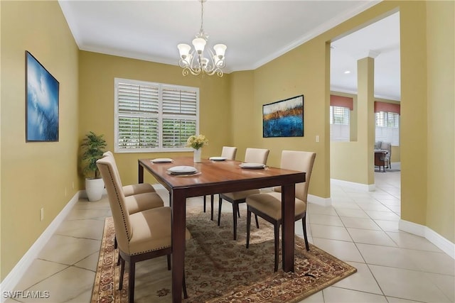 dining space with ornamental molding, light tile patterned flooring, baseboards, and an inviting chandelier