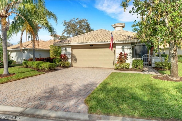 view of front of house featuring decorative driveway, stucco siding, an attached garage, a tiled roof, and a front lawn