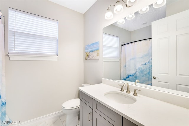 bathroom featuring plenty of natural light, toilet, and vanity