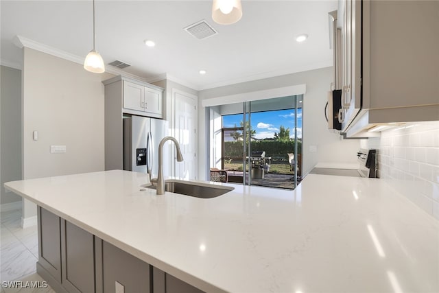 kitchen with sink, tasteful backsplash, pendant lighting, gray cabinets, and appliances with stainless steel finishes