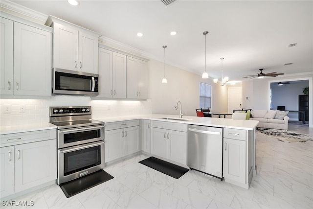 kitchen with sink, kitchen peninsula, stainless steel appliances, and hanging light fixtures