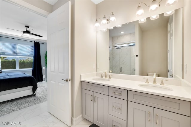 bathroom with vanity, toilet, ceiling fan, and a shower with shower door