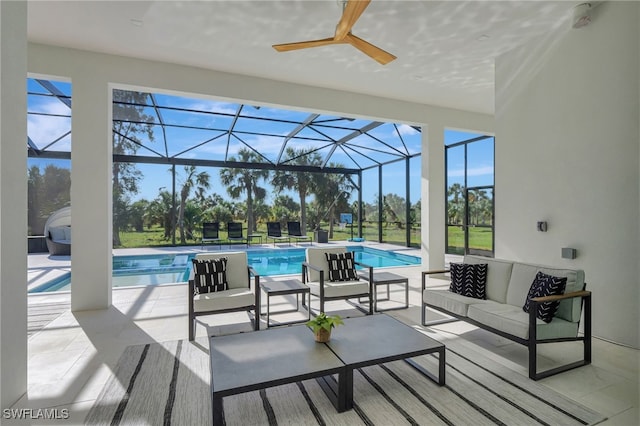 view of pool with a patio, outdoor lounge area, ceiling fan, and glass enclosure