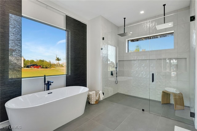 bathroom with tile patterned floors, plus walk in shower, and tile walls