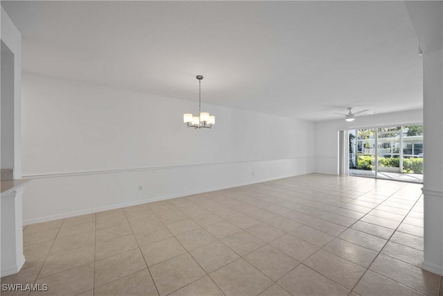 tiled spare room with ceiling fan with notable chandelier