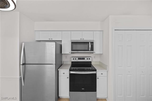 kitchen with stainless steel appliances and white cabinetry