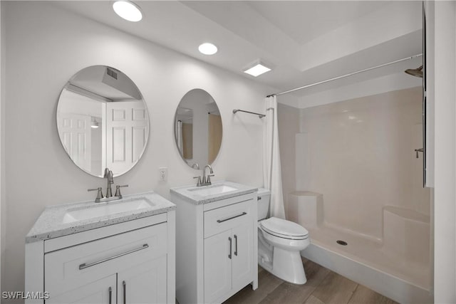 bathroom with a shower with curtain, toilet, wood-type flooring, and vanity