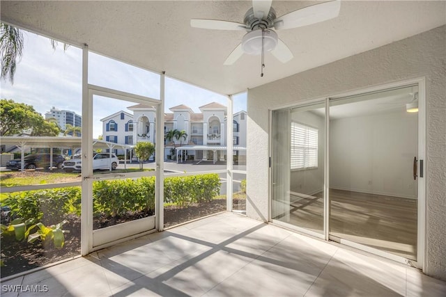 unfurnished sunroom with ceiling fan