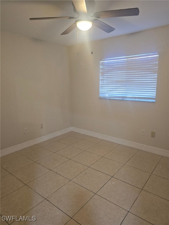 tiled spare room with ceiling fan