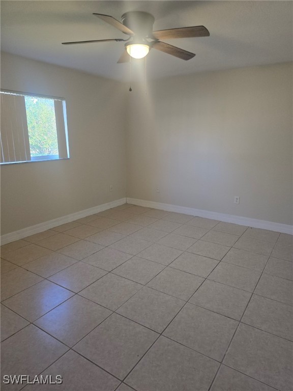 unfurnished room with ceiling fan and light tile patterned flooring