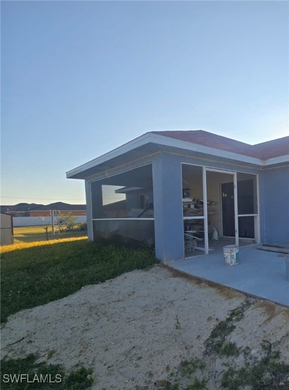 back of house with a sunroom and a mountain view