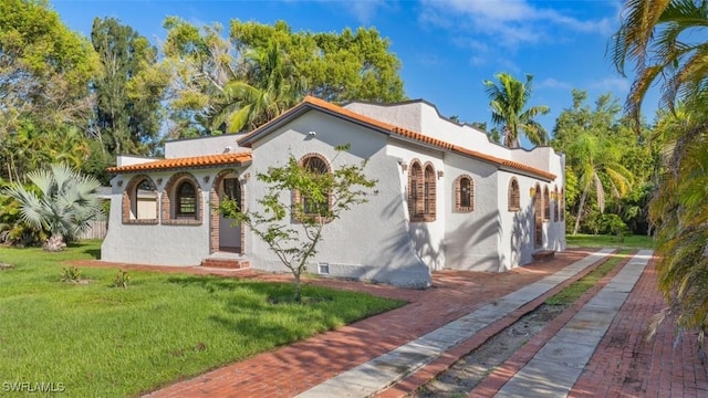 mediterranean / spanish-style home with a front yard