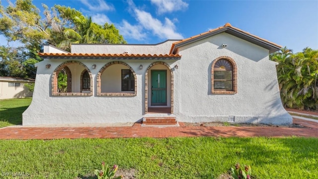 mediterranean / spanish home featuring a front yard