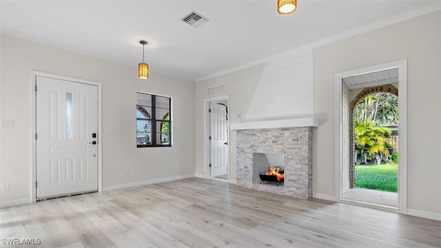 unfurnished living room featuring crown molding, a fireplace, and light hardwood / wood-style flooring