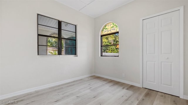 empty room with light hardwood / wood-style flooring and a healthy amount of sunlight