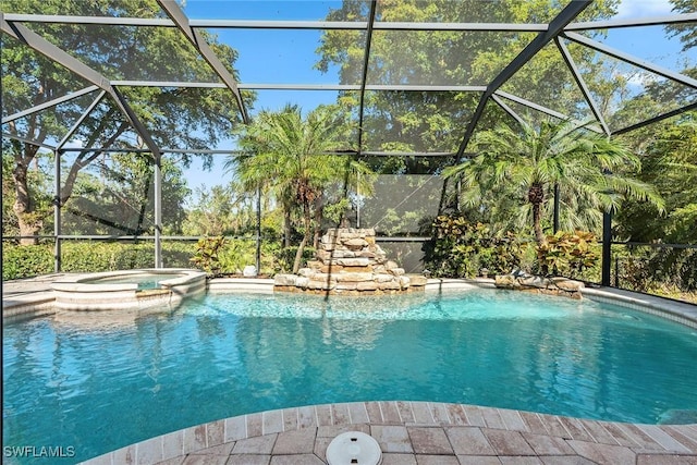 view of swimming pool featuring glass enclosure and an in ground hot tub