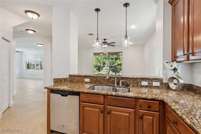 kitchen featuring ceiling fan, sink, dark stone countertops, dishwasher, and light tile patterned flooring