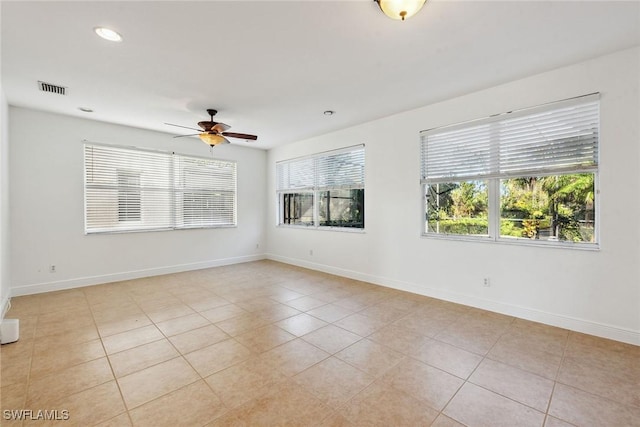 tiled spare room with ceiling fan