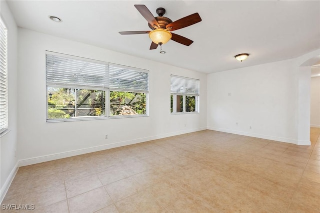 tiled empty room featuring ceiling fan