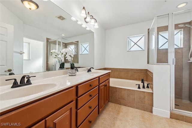 bathroom with tile patterned floors, plenty of natural light, shower with separate bathtub, and vanity