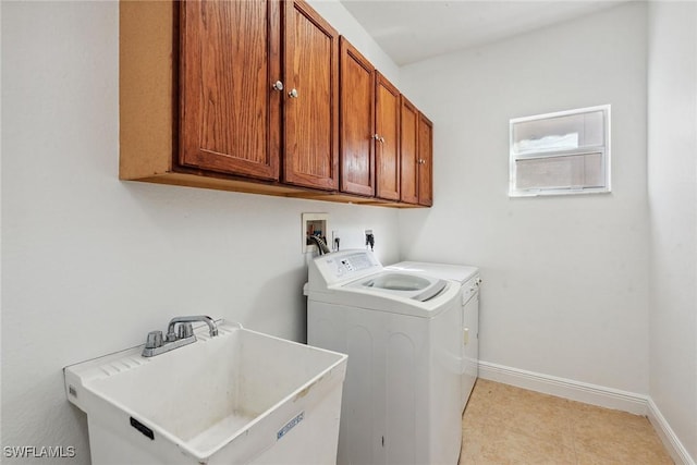 laundry room featuring washer and clothes dryer, cabinets, and sink