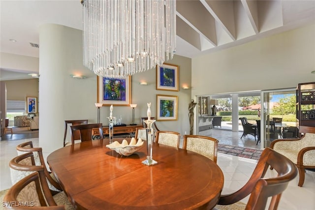 dining room featuring light tile patterned flooring, a towering ceiling, and an inviting chandelier