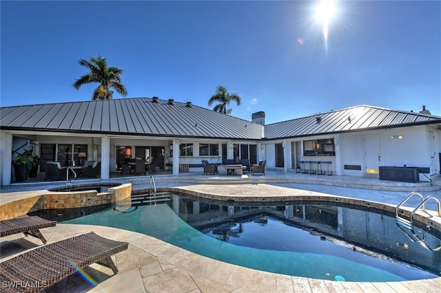 view of swimming pool with a patio area, a bar, and an in ground hot tub