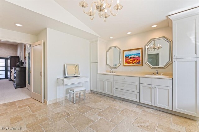 bathroom featuring vanity, lofted ceiling, and an inviting chandelier