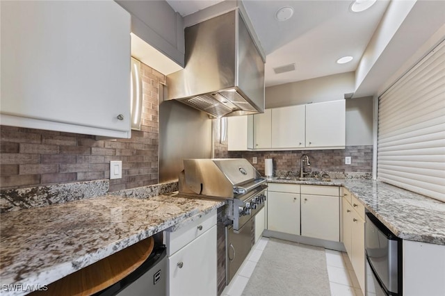 kitchen featuring white cabinetry, light stone counters, wall chimney exhaust hood, and light tile patterned flooring