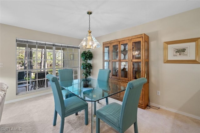 carpeted dining room with a chandelier