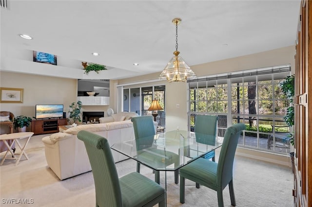 carpeted dining space featuring a notable chandelier