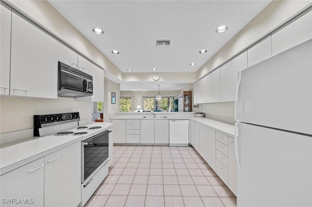 kitchen featuring white appliances, sink, light tile patterned floors, white cabinets, and a chandelier