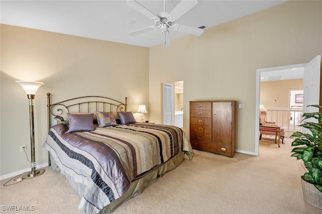 carpeted bedroom featuring a high ceiling, ensuite bathroom, and ceiling fan