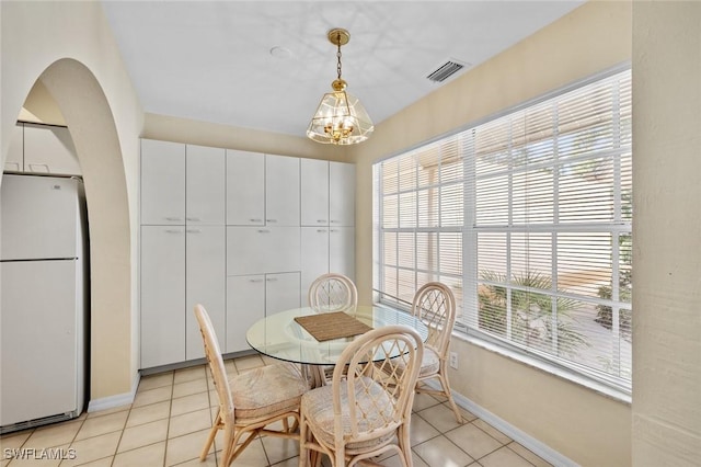 tiled dining area with an inviting chandelier