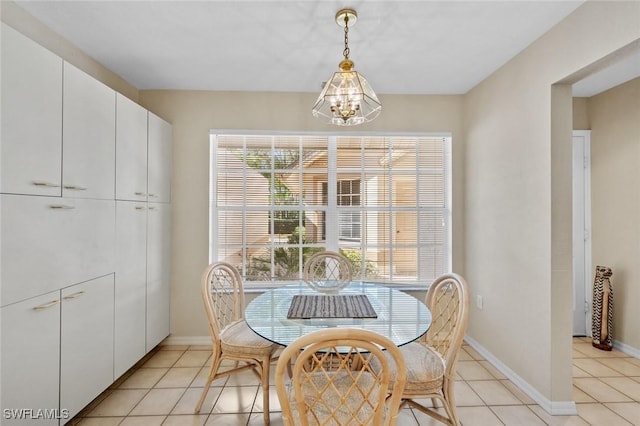 dining space with light tile patterned floors and an inviting chandelier