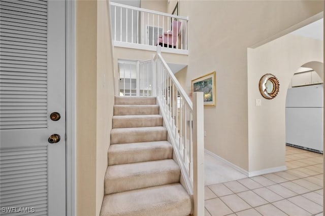 20190 Golden Panther Dr Unit 3, Estero, FL 33928 - staircase with tile patterned flooring, arched walkways, and a high ceiling
