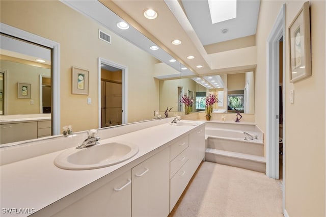 bathroom featuring a tub to relax in, vanity, and a skylight