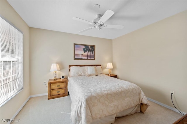 carpeted bedroom featuring multiple windows and ceiling fan